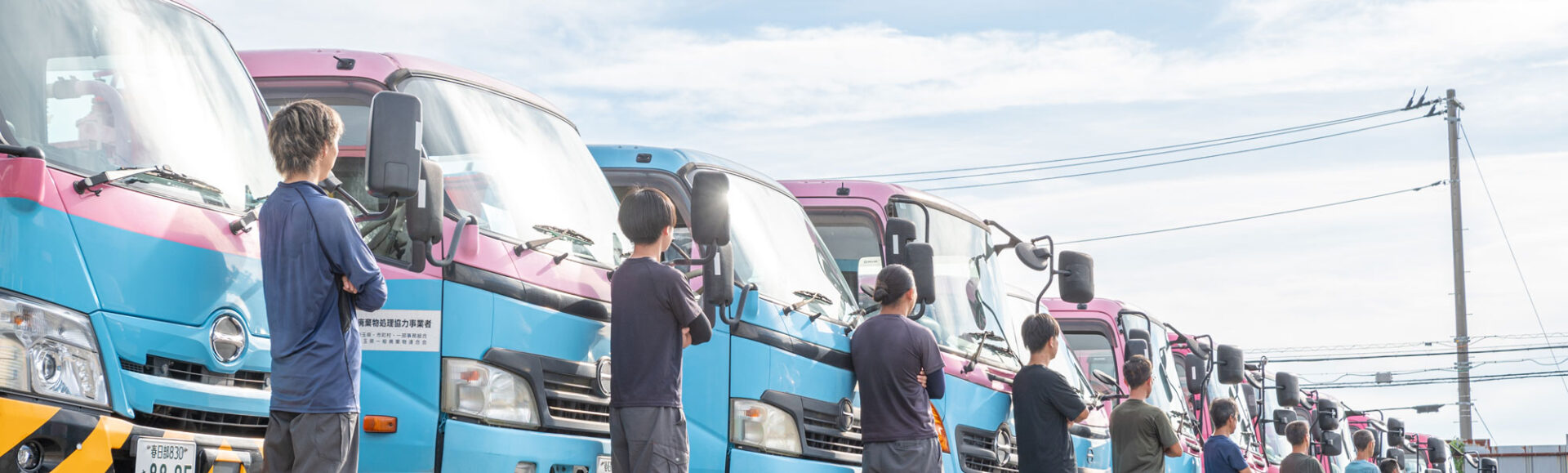 トラックの前で空を見上げる社員